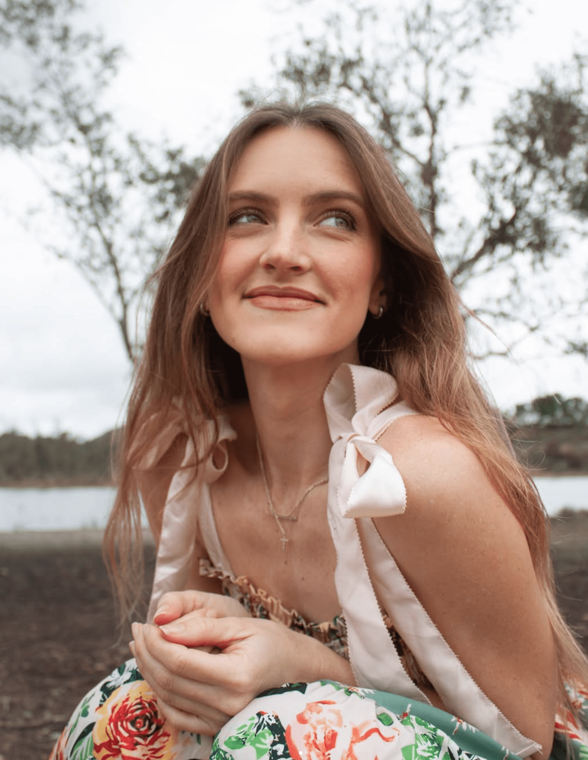 Portrait of a laughing person with curly hair wearing a white shirt