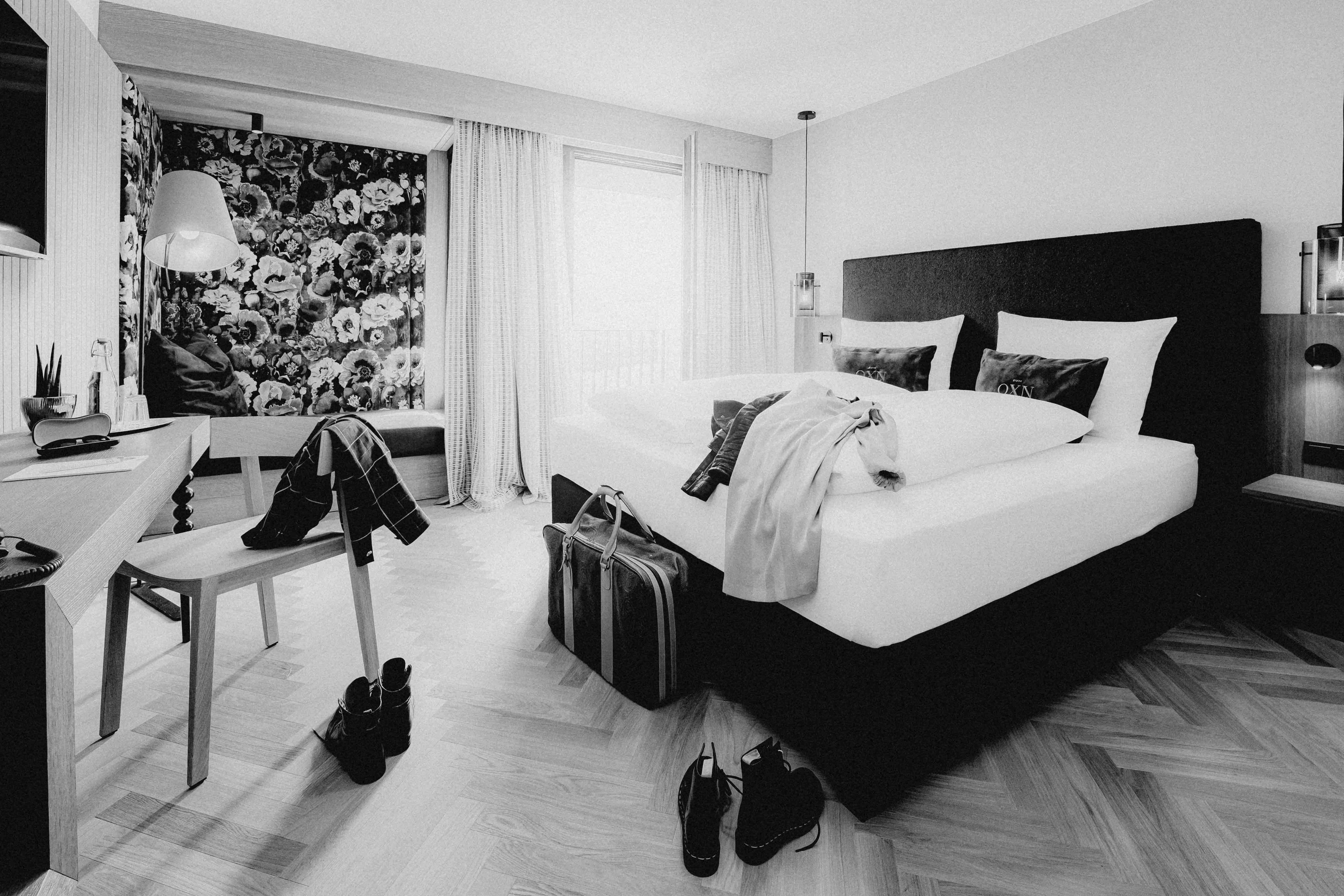 A modern bedroom featuring a large bed, a stylish chair, and decorative artwork on the wall.
