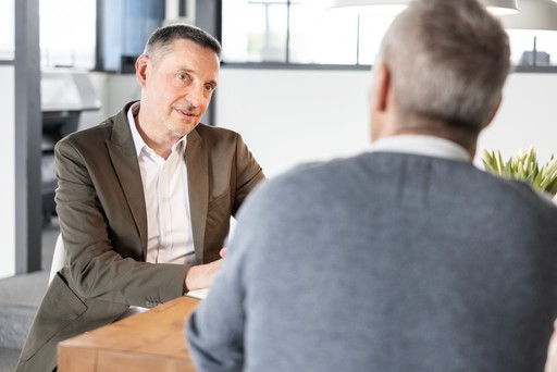 Business Coach Stefan Bischo von Leadtransform steht entspannt im modernen Büro