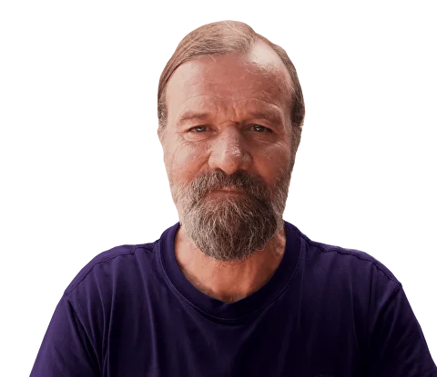 A young man with dark hair smiles at the camera, set against a modern indoor background.