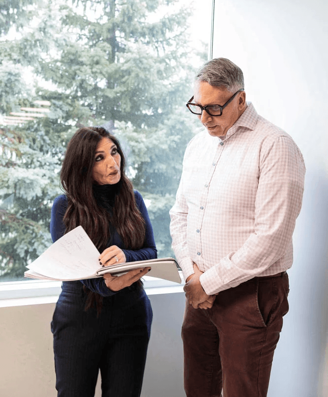 Two SteriMax team members reviewing documents together in an office by a window.