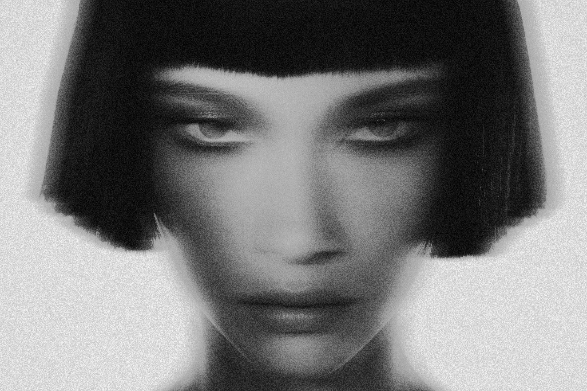 Woman with a sharp black bob in a soft motion-blur portrait, black and white