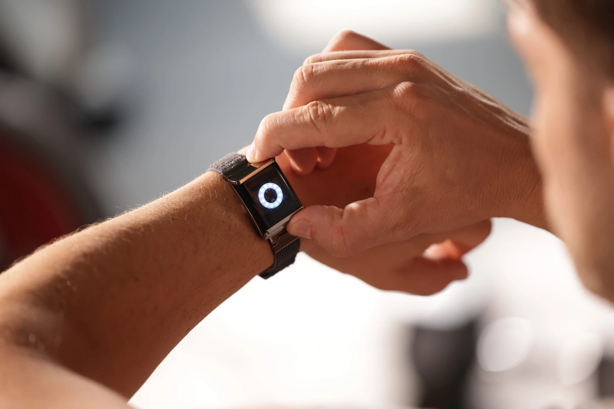 A finger touching Halo worn on the wrist