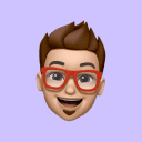 Cartoon avatar with brown hair, red glasses, beard, and a cheerful expression on a light purple background.