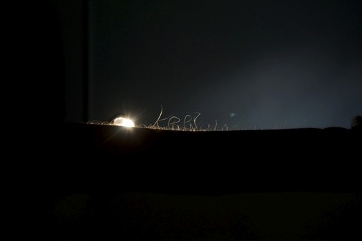 abstract rounded thin shapes in the dark are illuminated slightly from the right side