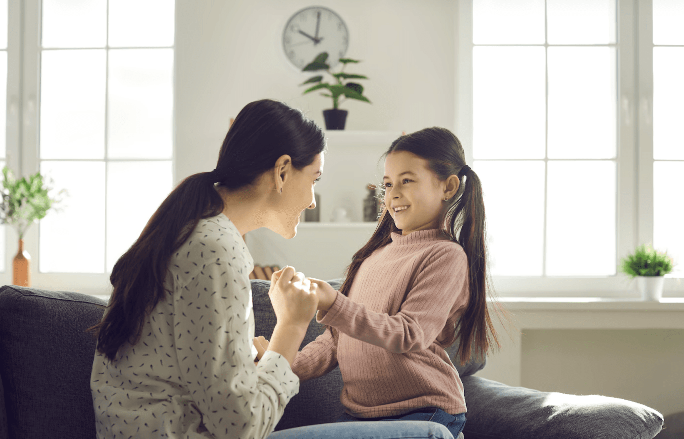 mother and daughter hold hands and look at each other