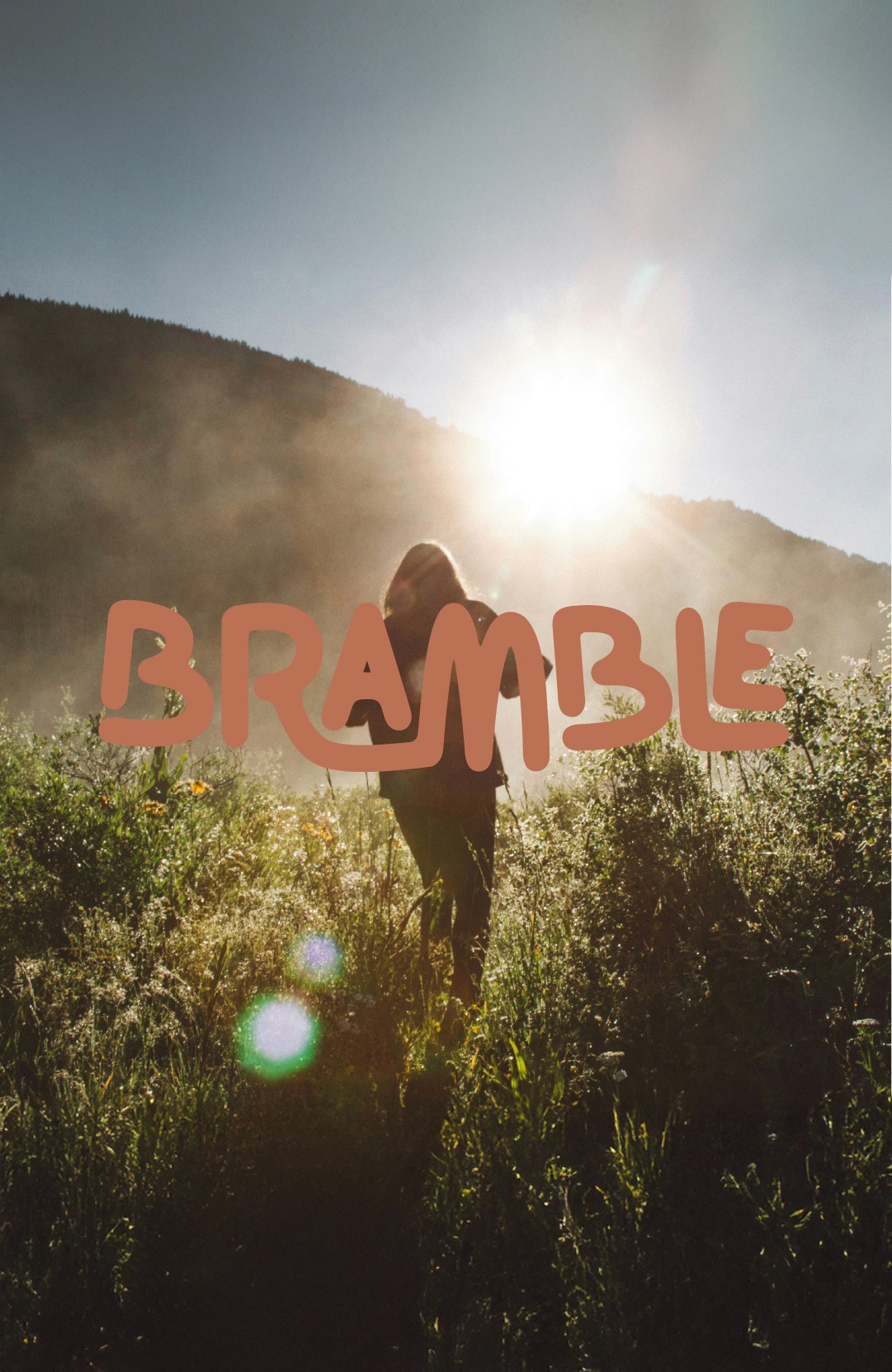 Woman walking through a field with Bramble logo imposed in center of image