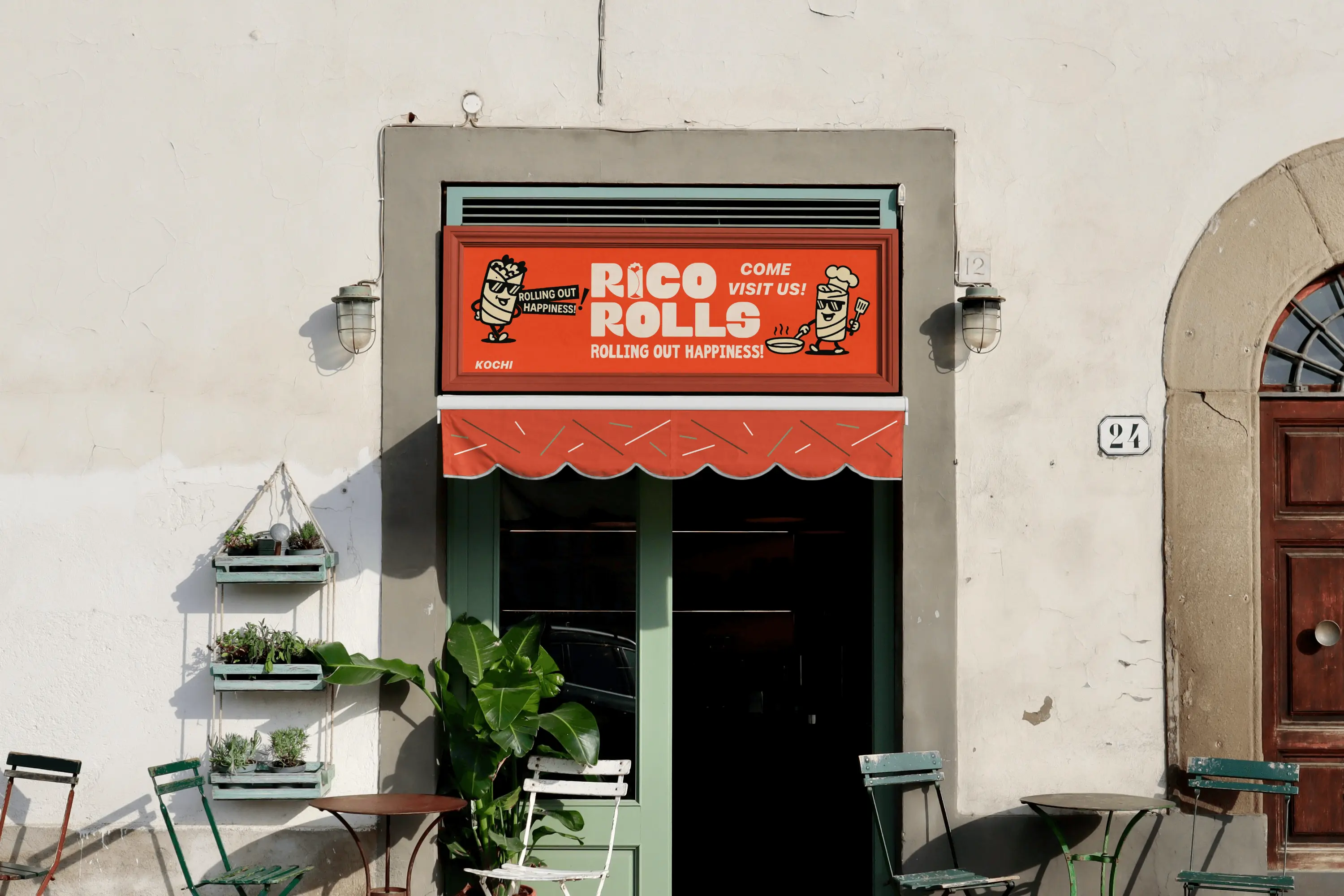 Rico Rolls storefront exterior featuring a bright red signboard with mascot illustrations and the tagline ‘Rolling Out Happiness,’ above a matching awning and outdoor café seating