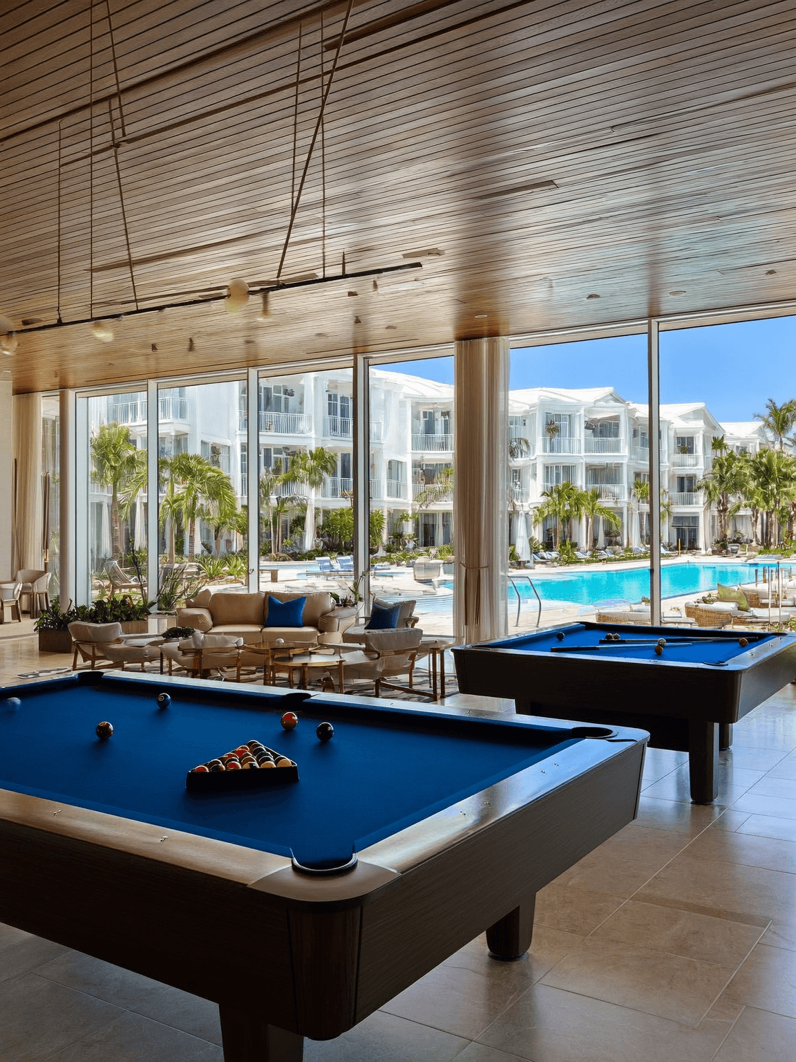 Clubhouse interior with pool tables and large windows.