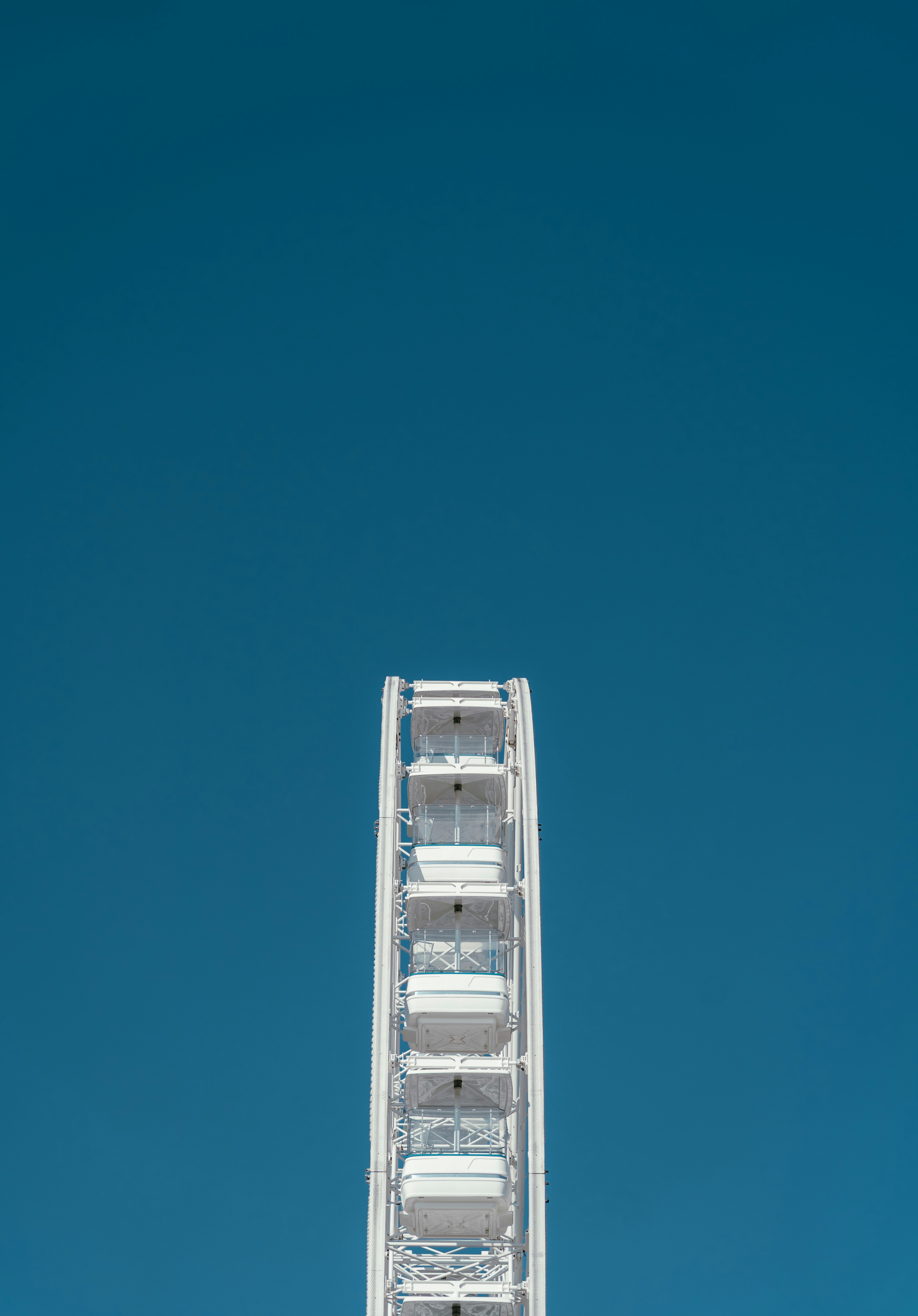 White ferris wheel against a clear blue sky
