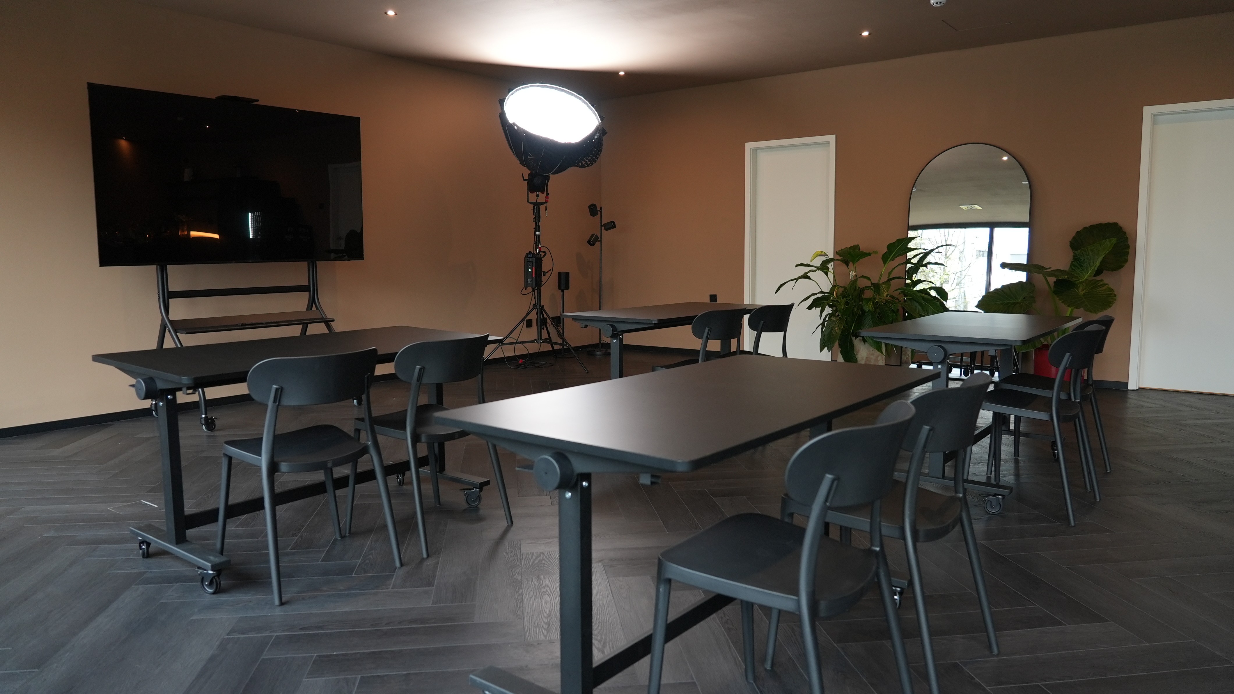 A person walks down a sunlit hallway with luggage.