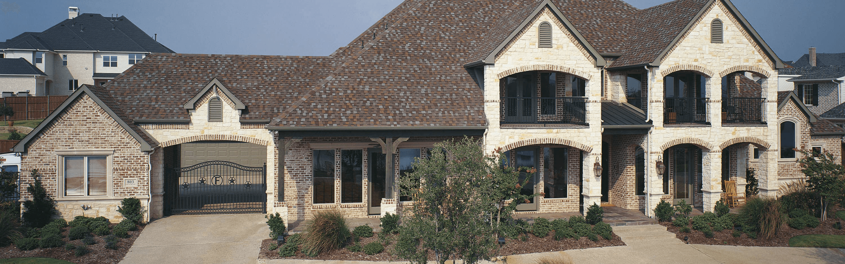 A beauty shot of a large elegant home with Titan XT shingles by Tamko on its roof.