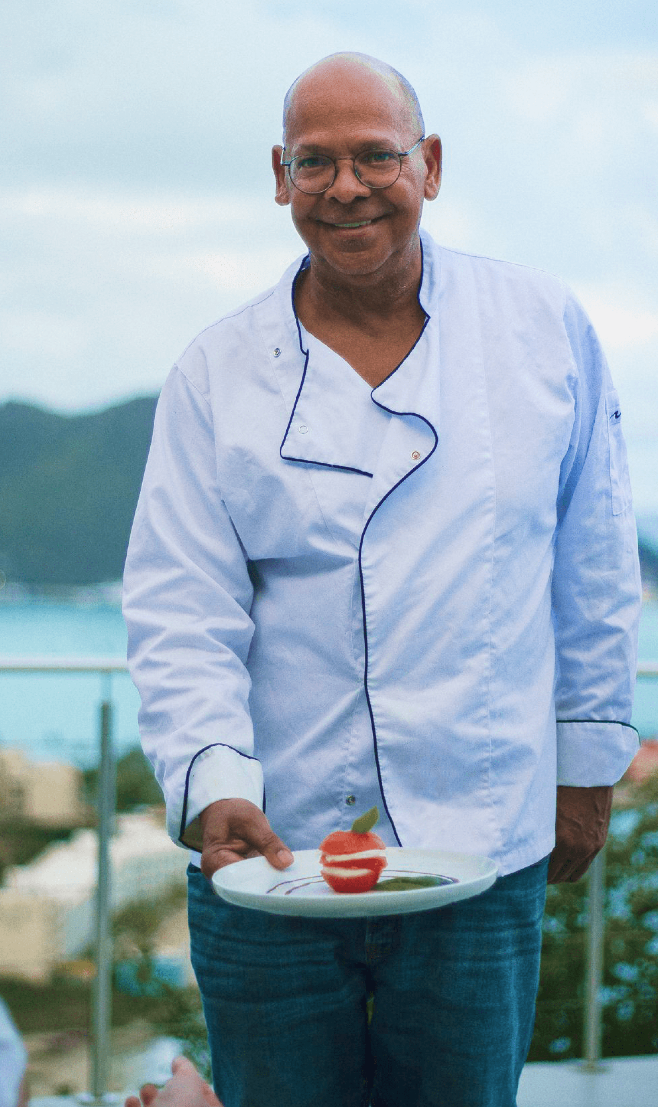 chef Ronny smiling while serving a dish.