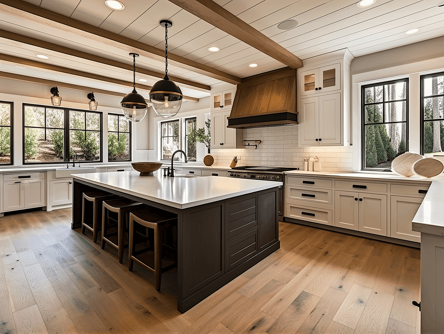 A classic kitchen with white cabinetry, wood accents, and a large island with dark wood trim. Pendant lights and exposed wooden beams add character to the space, while large windows bring in ample natural light.