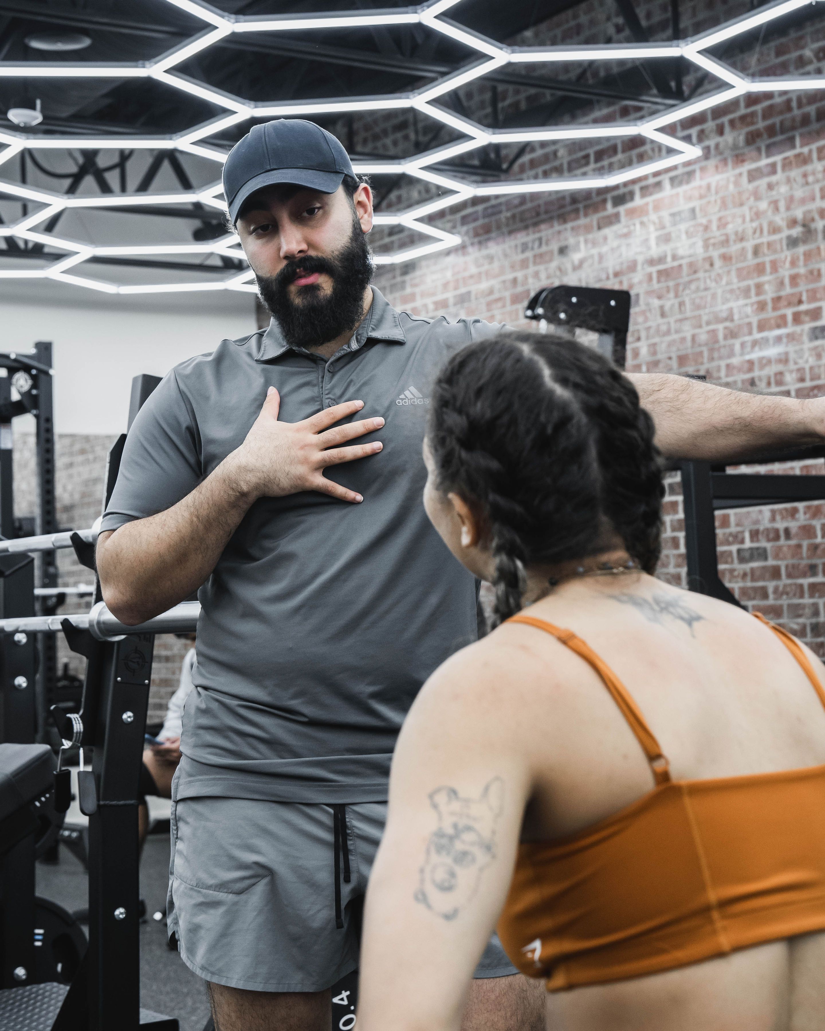 Coach Ario explaining proper movement pattern to a client