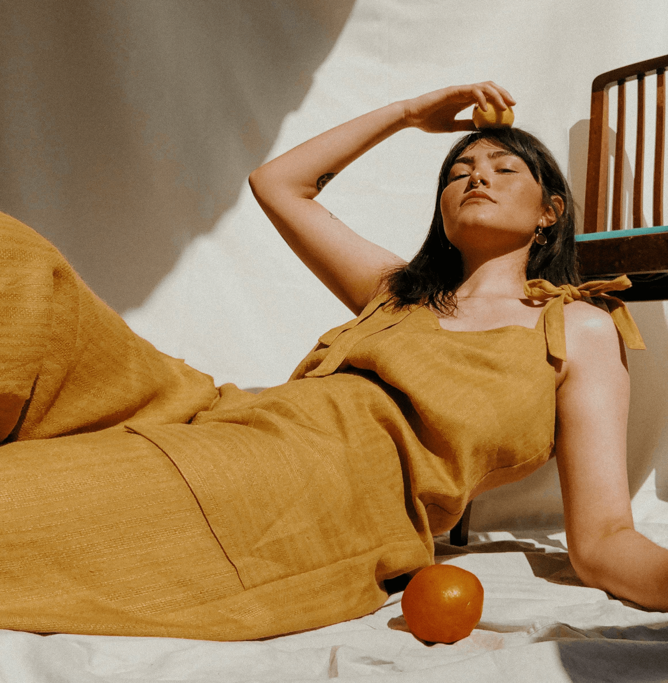 woman in brown sleeveless dress lying on bed