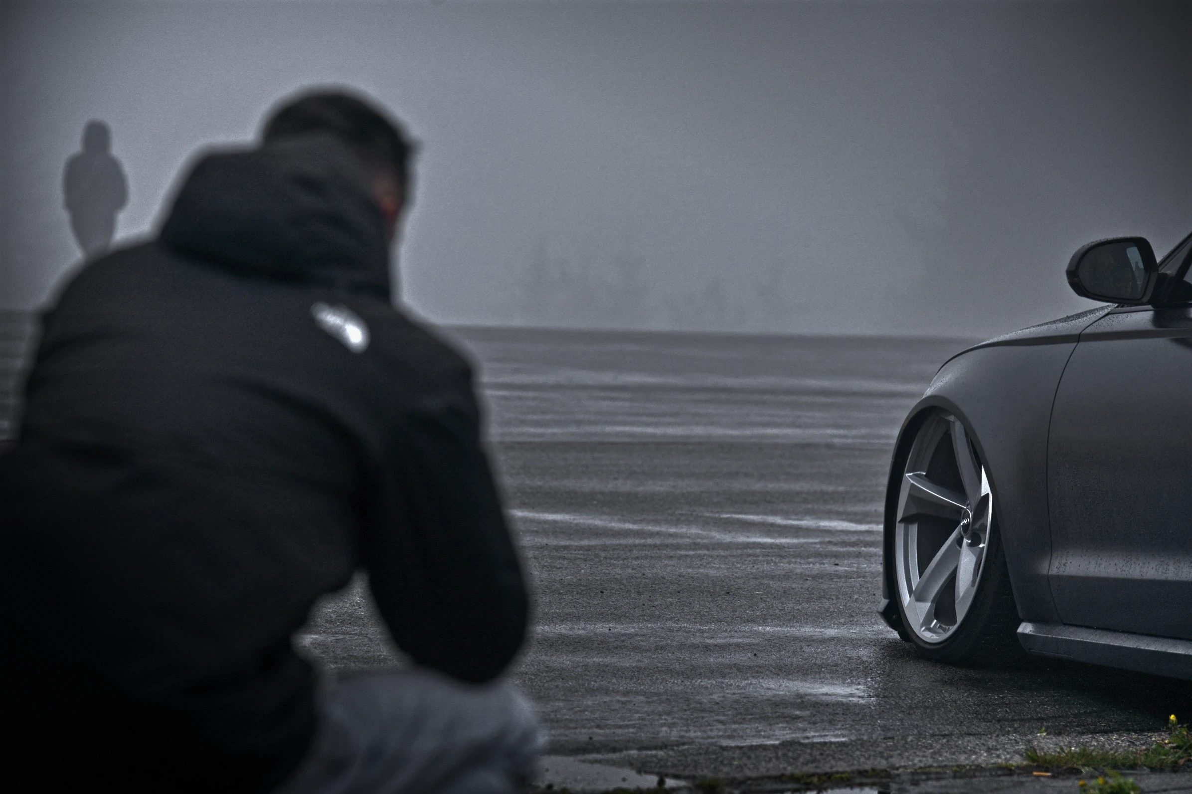 Fotograf dokumentiert einen tiefergelegten Audi RS6 in Daytonagrau während des Audi RS Treffens Crottendorf 2025 im morgendlichen Nebel.
