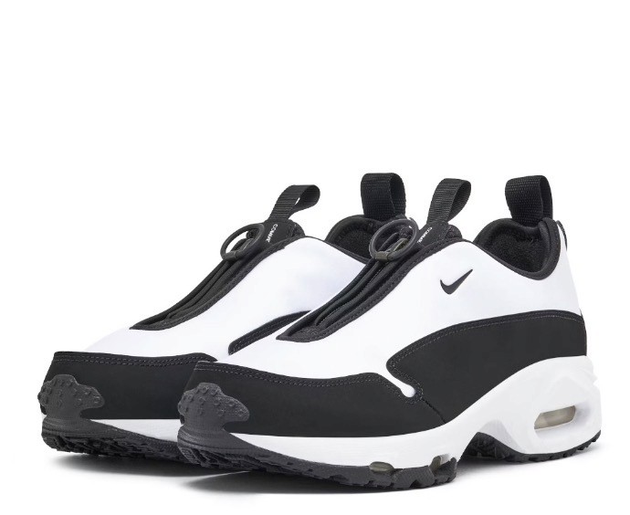 Angled view of a black athletic sneaker lying on its side, showcasing its textured, high-traction sole design against a neutral background.