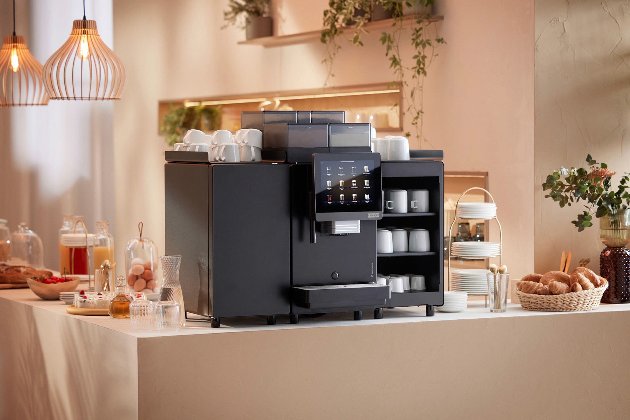 Produktbild von neuer A-Linie Kaffee-Vollautomat in schwarz bestehend aus Kaffeemaschine, Kühlschrank-Modul und Tassenwärmer in einer Buffet-Umbebung (Franke, 2025)