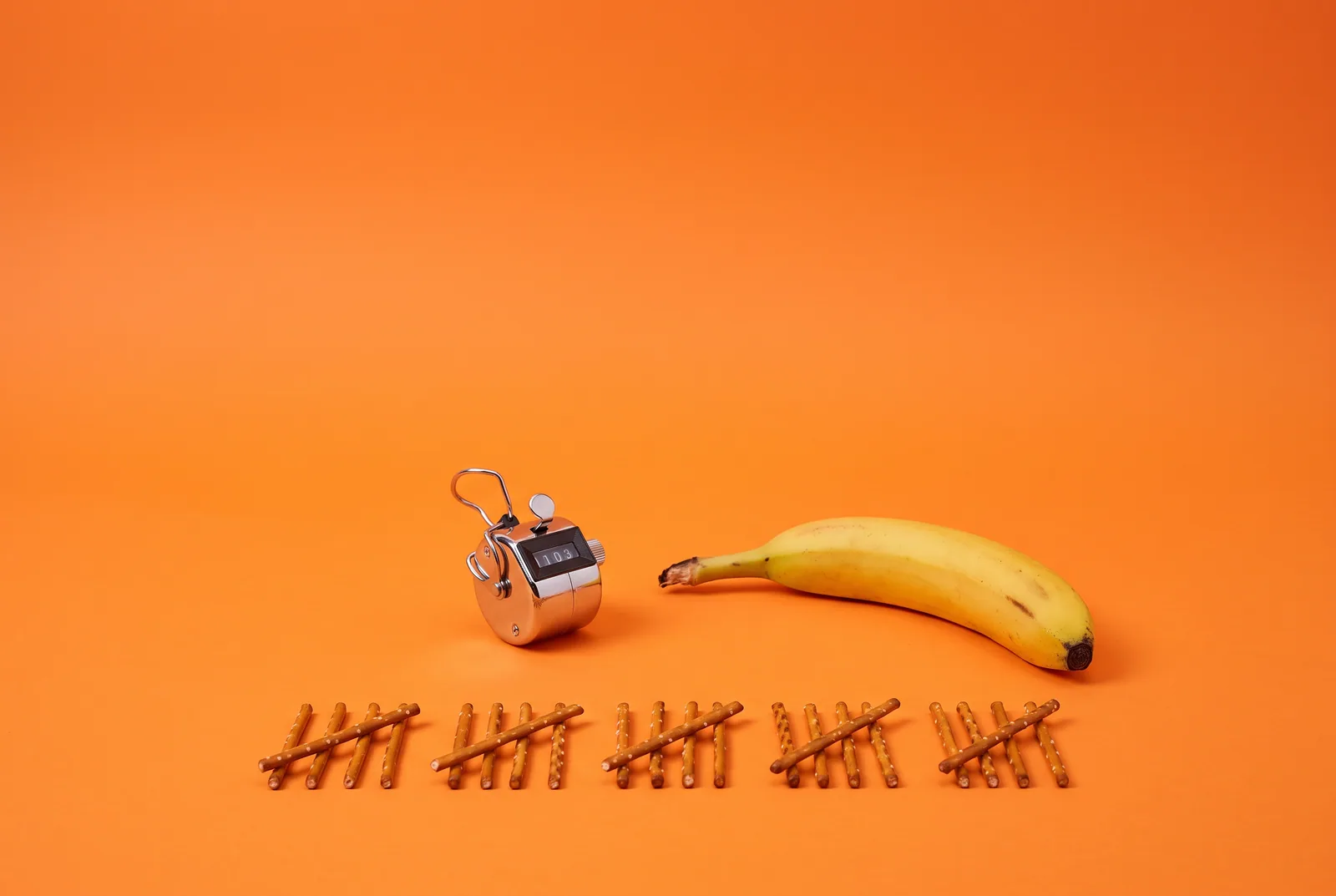 A banana beside a tally counter and pretzel-stick tally marks, telling a glance from a pattern when your husband looks at other women online