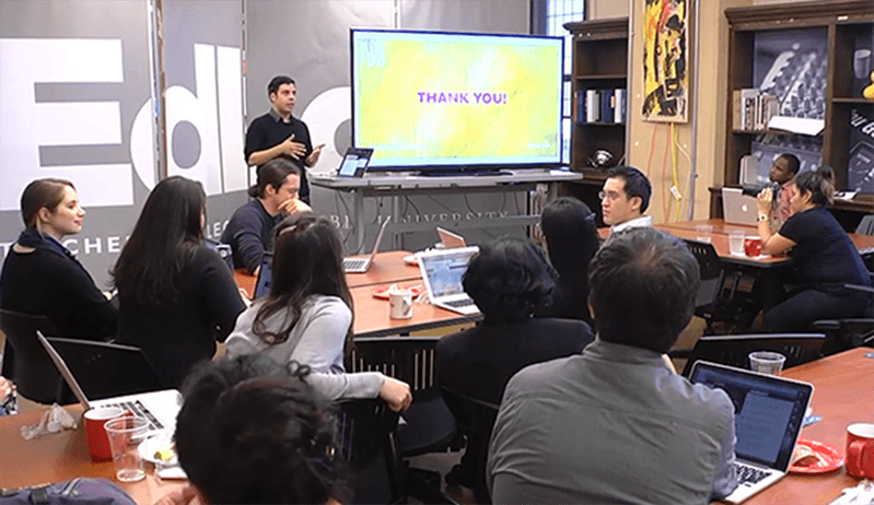 a man presenting two hot dogs who eat fruits and vegetables to a room full of people