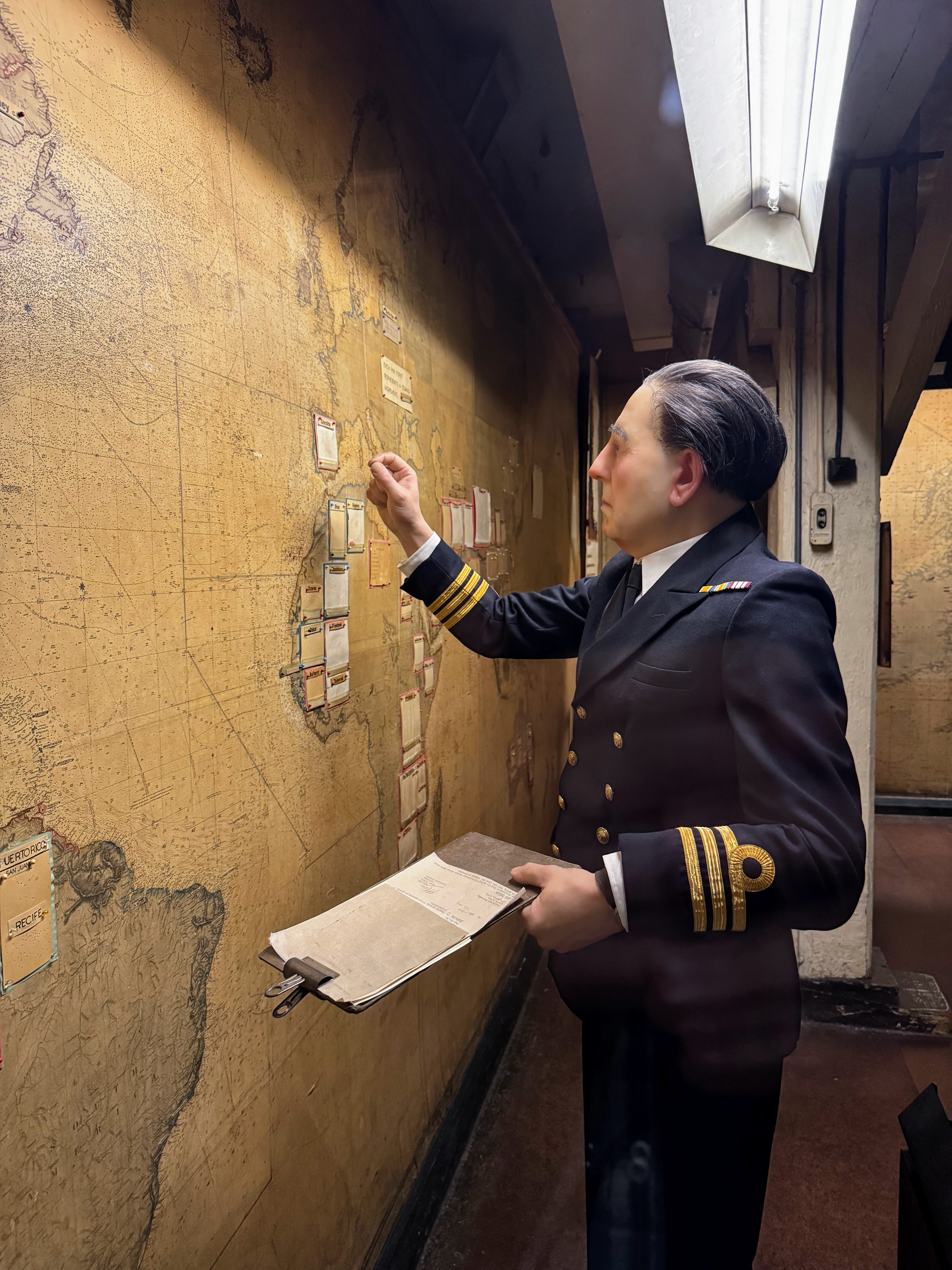 A wax figure of a military commander putting pins in a World War 2 map at the Churchill War Rooms in London.