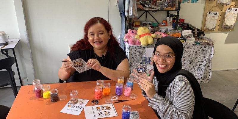 Stephanie with a customer, crafting perler bead designs