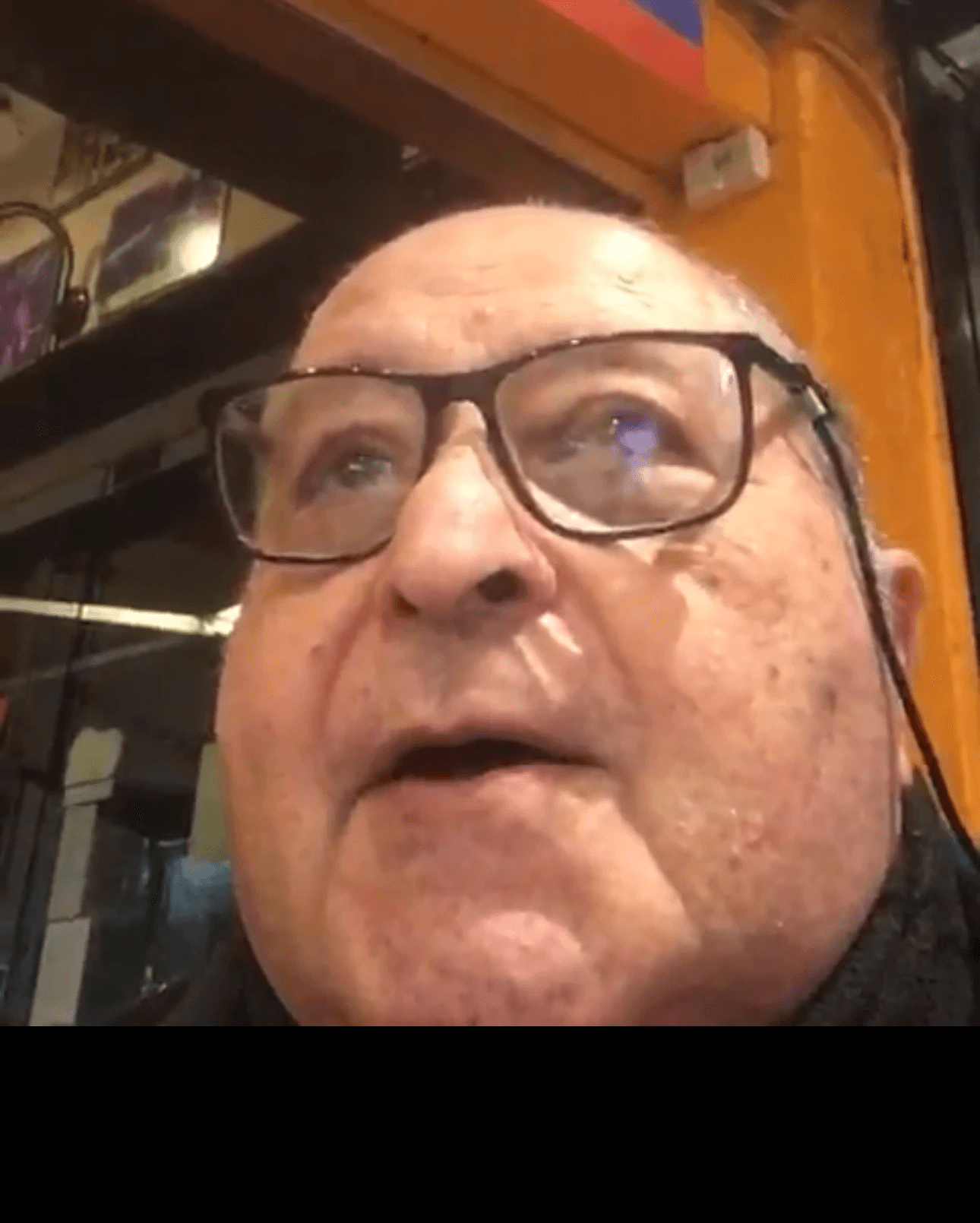 A person wearing the grey coat smiling in a cozy sunlight