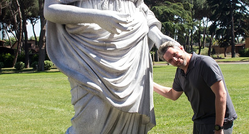 A male posing with the scupture