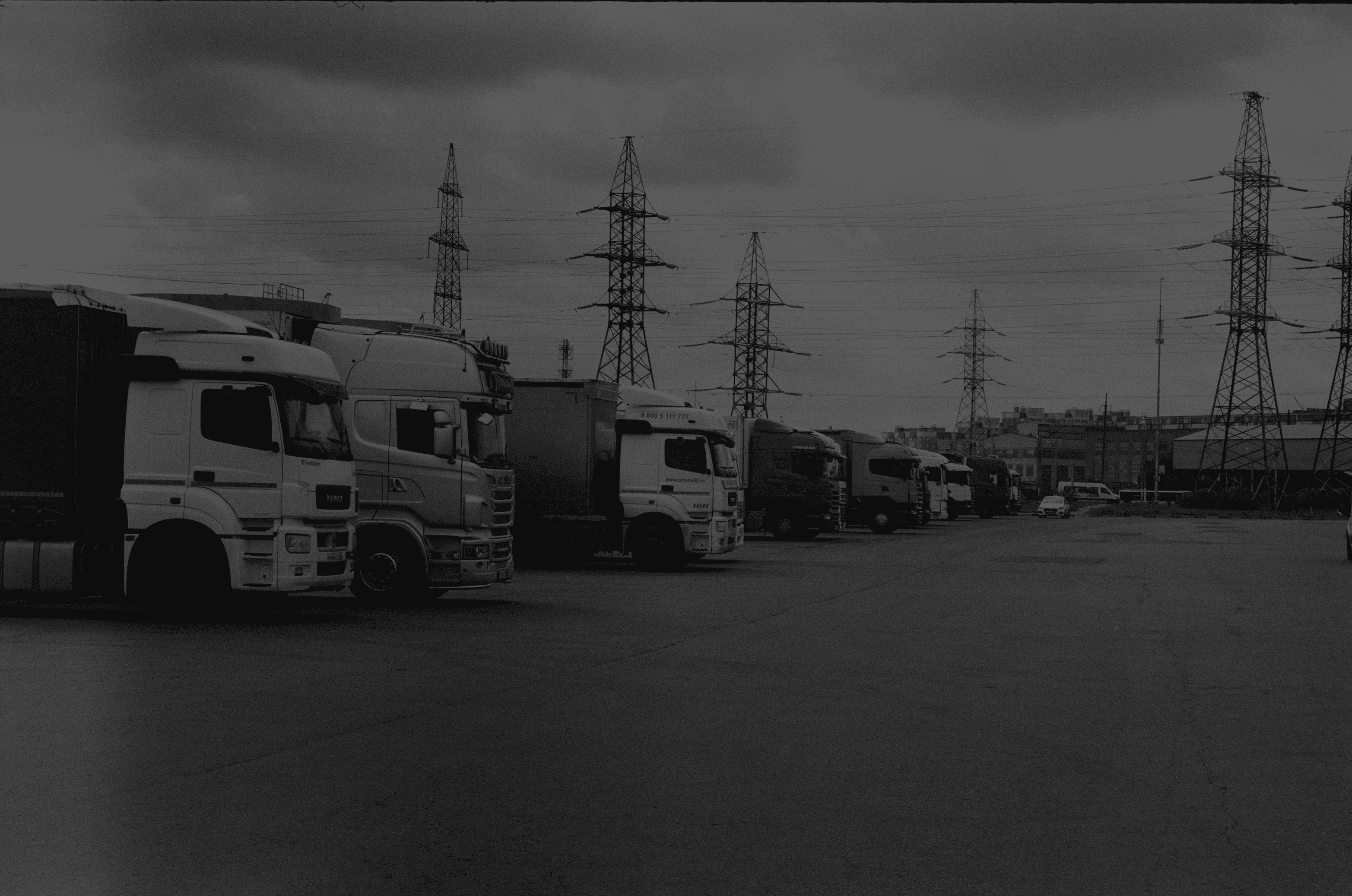 a black and white photo of trucks parked in a lot
