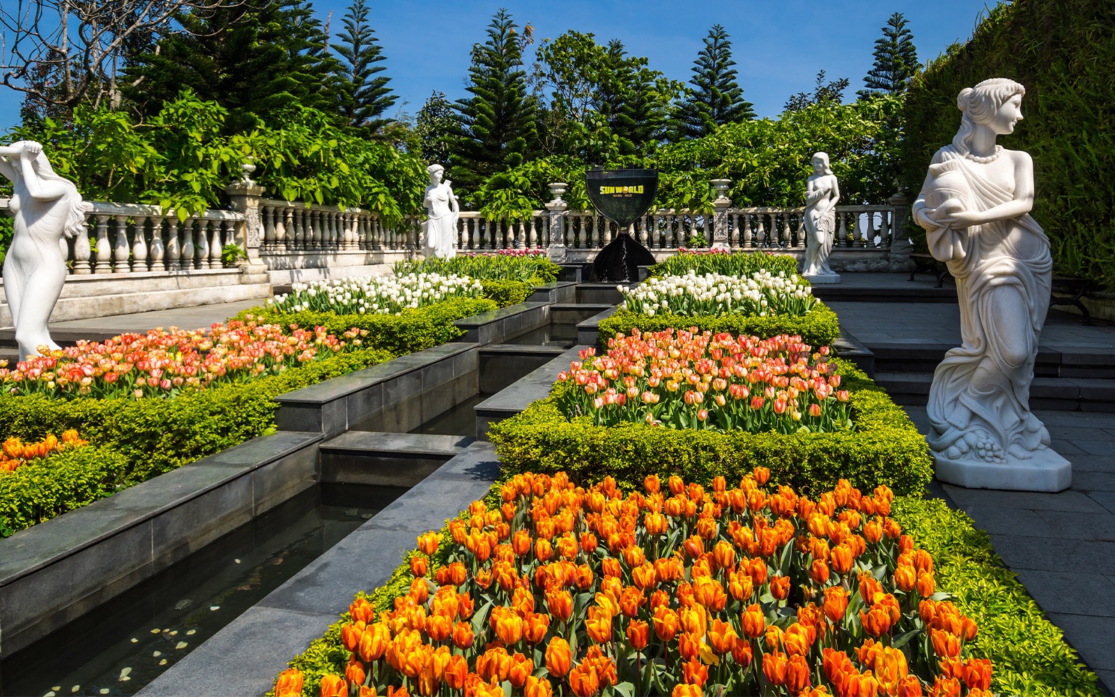 Ba Na Hills garden with colorful tulips and classical statues.
