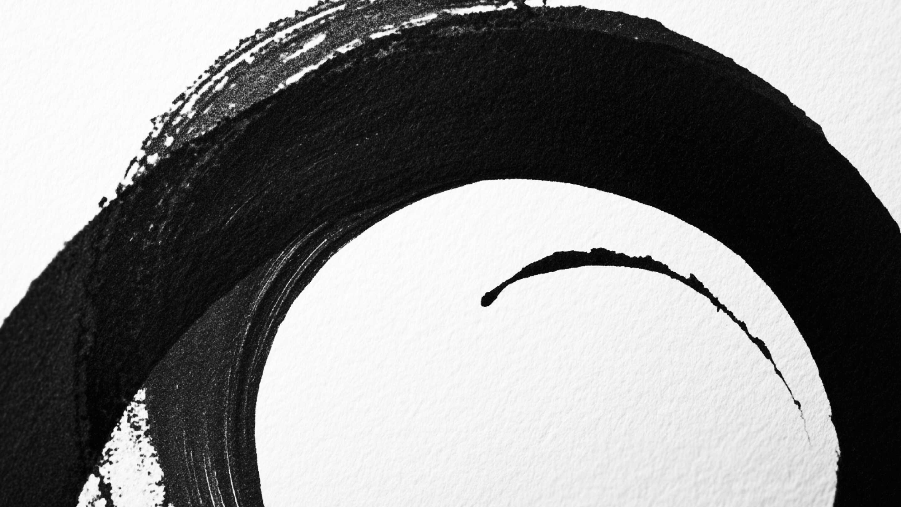 Bold black ink brush stroke on textured paper