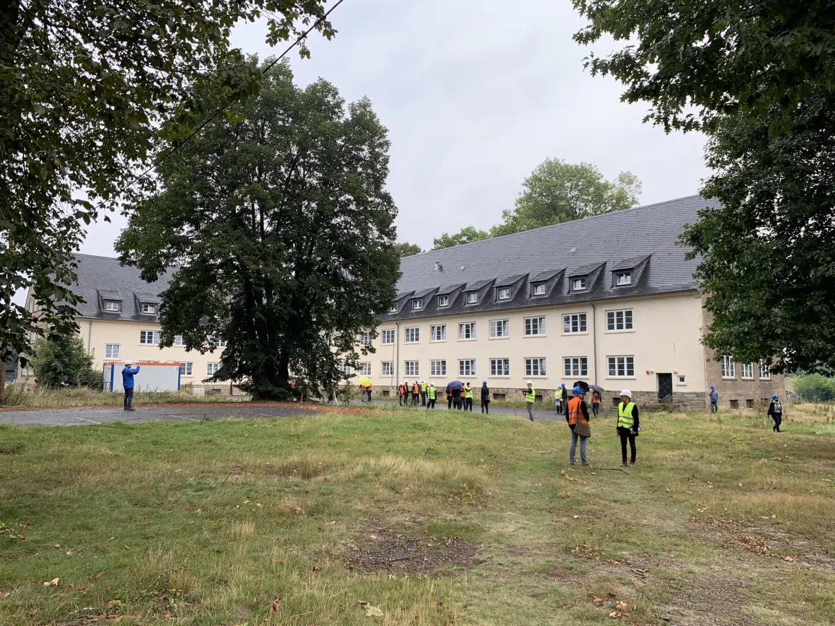 Isometrische Zeichnung eines Bauprojekts mit mehreren Gebäuden und markierten Strukturen in Rot