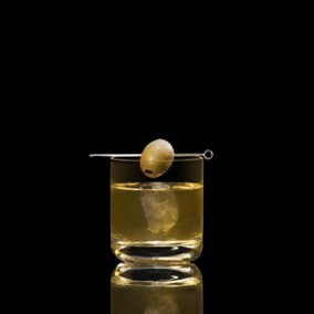 A closeup of a Dirty Double drink against a dark background.