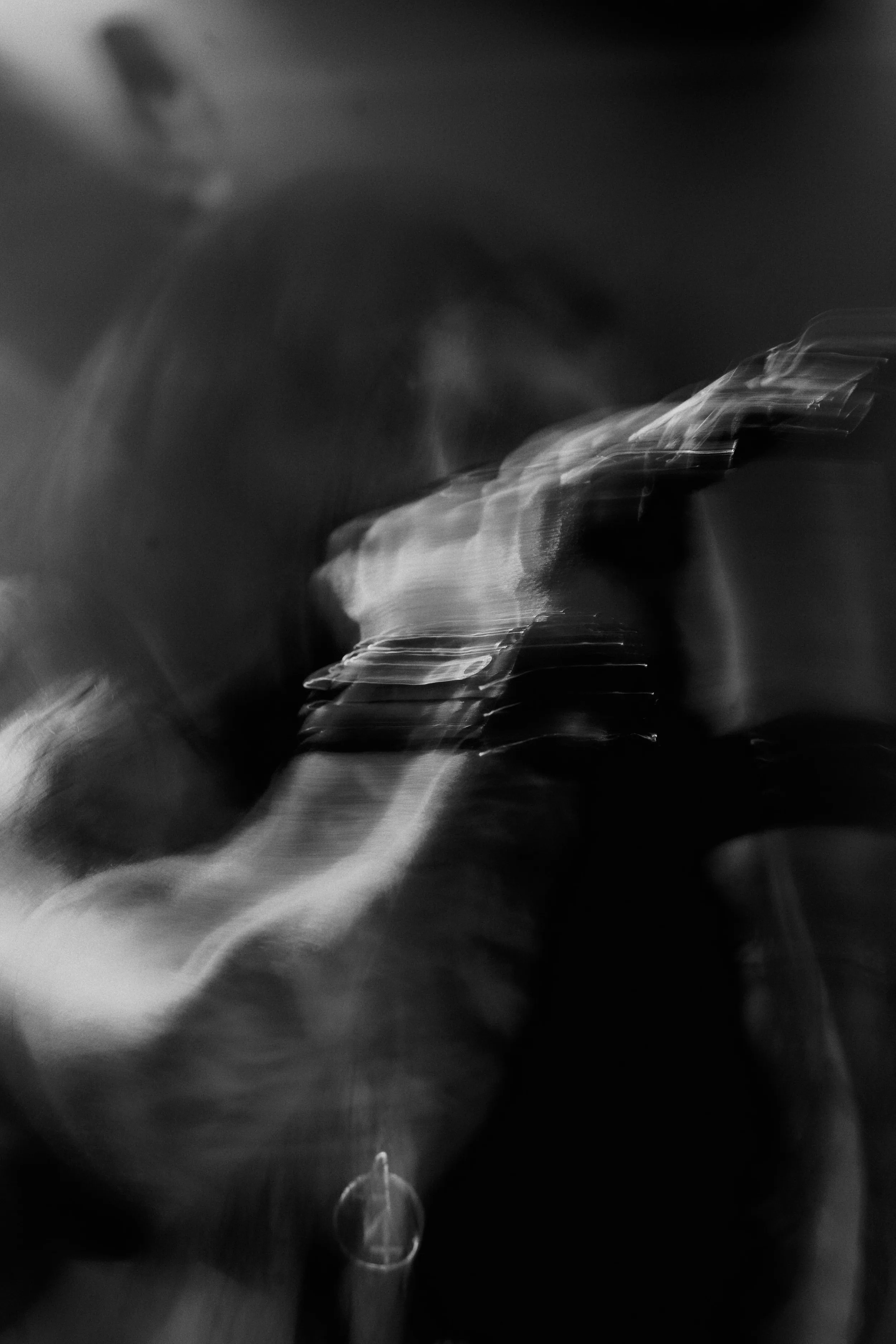 Photographie de concert en noir et blanc, volontairement floue, capturant le mouvement et l'énergie de l'artiste