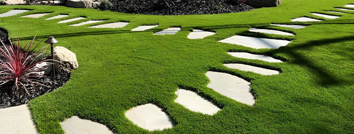 Stone slabs create a walking path and show just how cushy Majestic 70 artificial turf by AGL Grass truly is.