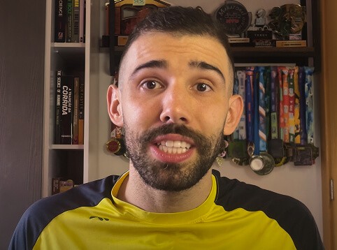 icone do treinador nestor da pro elite dando aula em um escritório com livro ao fundo