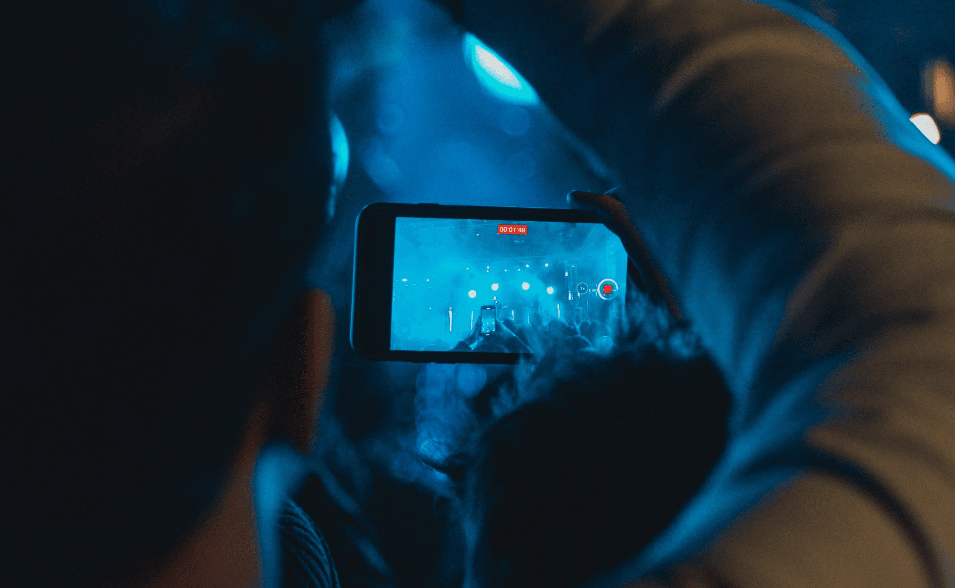guy filming a concert
