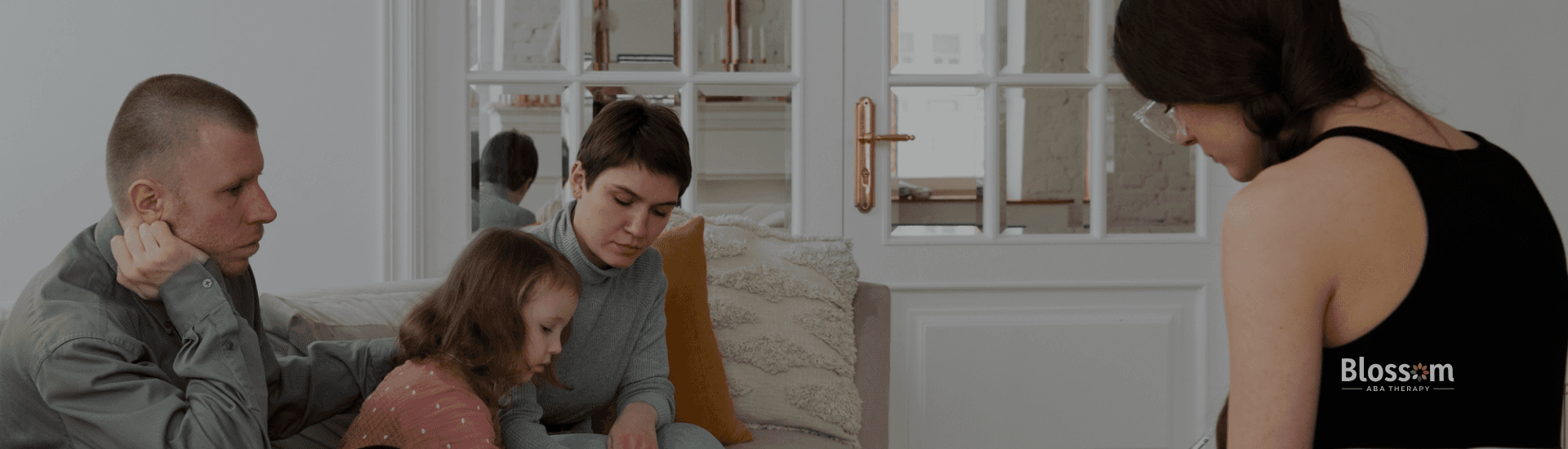 A therapist is talking to the parents of an autistic child before ABA therapy