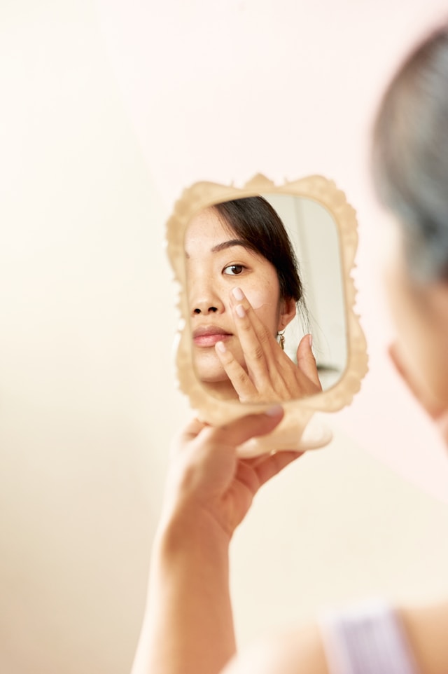 Woman checking beautiful face in mirror