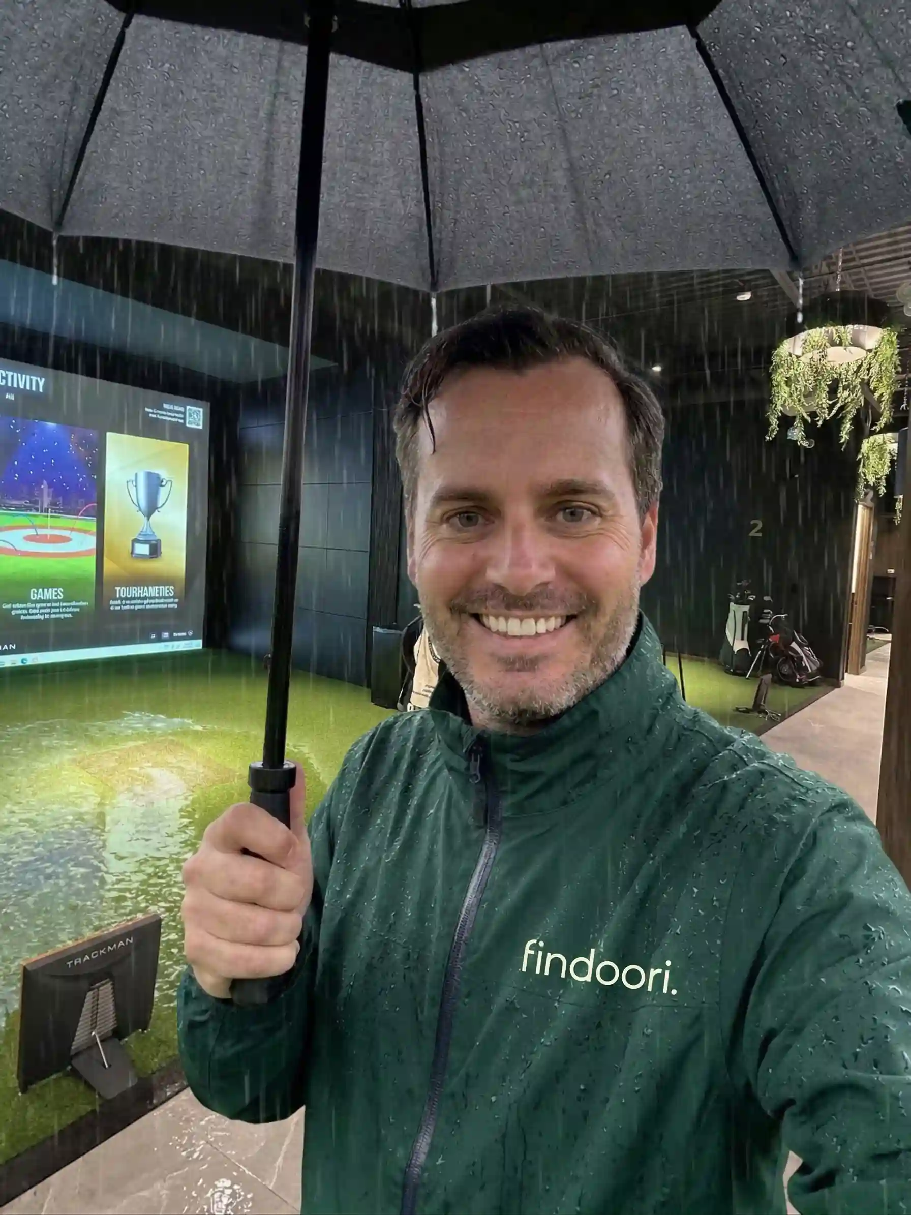 timothy-holding-umbrella-in-the-rain-in-golfsimulator