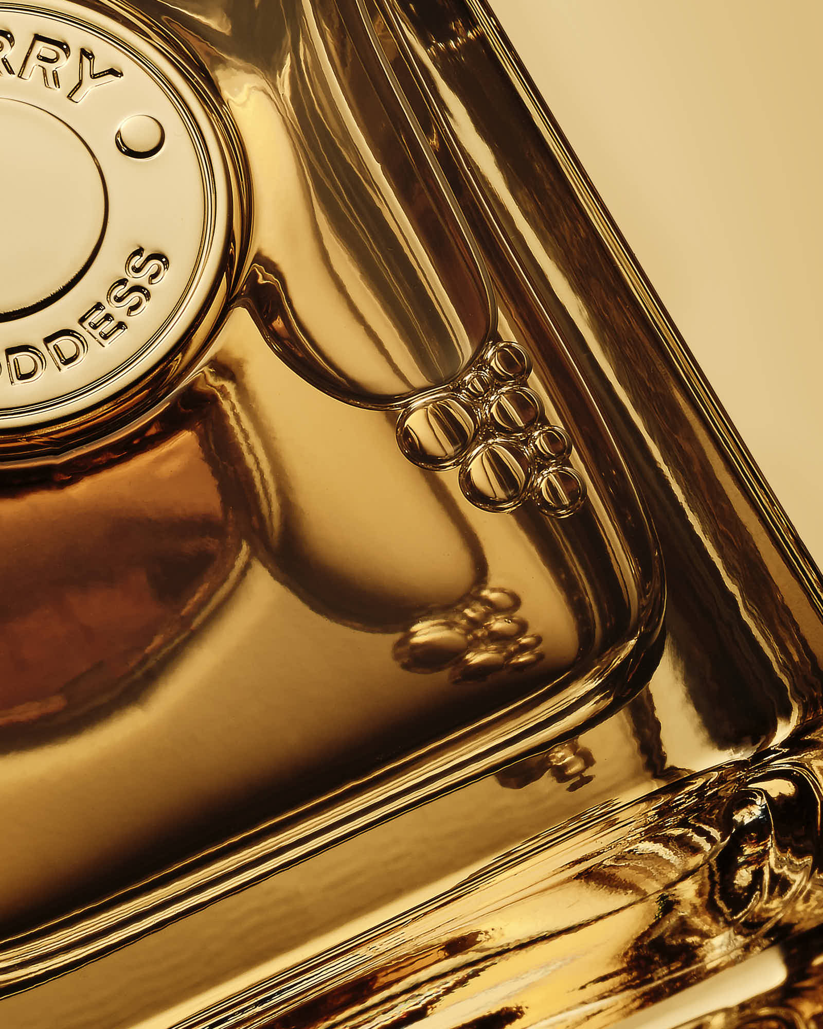 Close-up of a gold perfume bottle, highlighting its intricate design and polished surface.