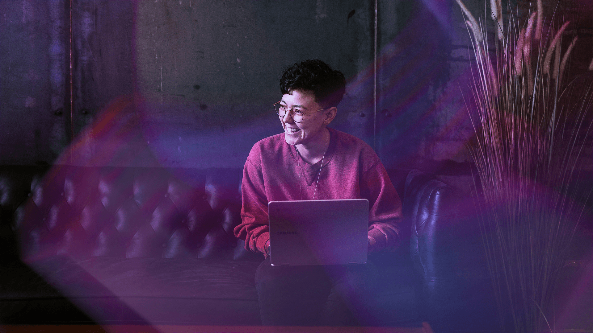 A woman sits behind her laptop, smiling, turning AI into experience advantage