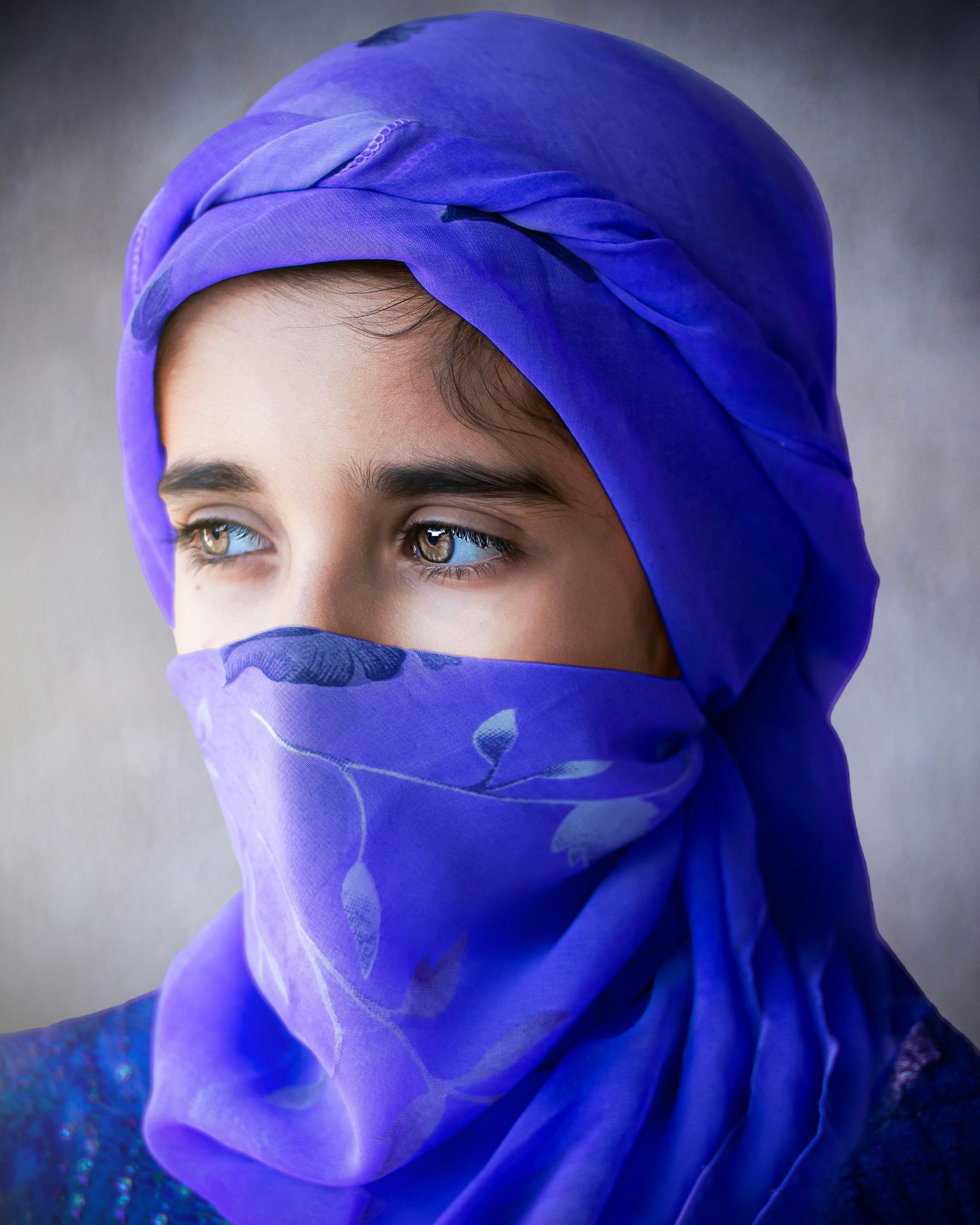 A woman with a blue scarf on her head