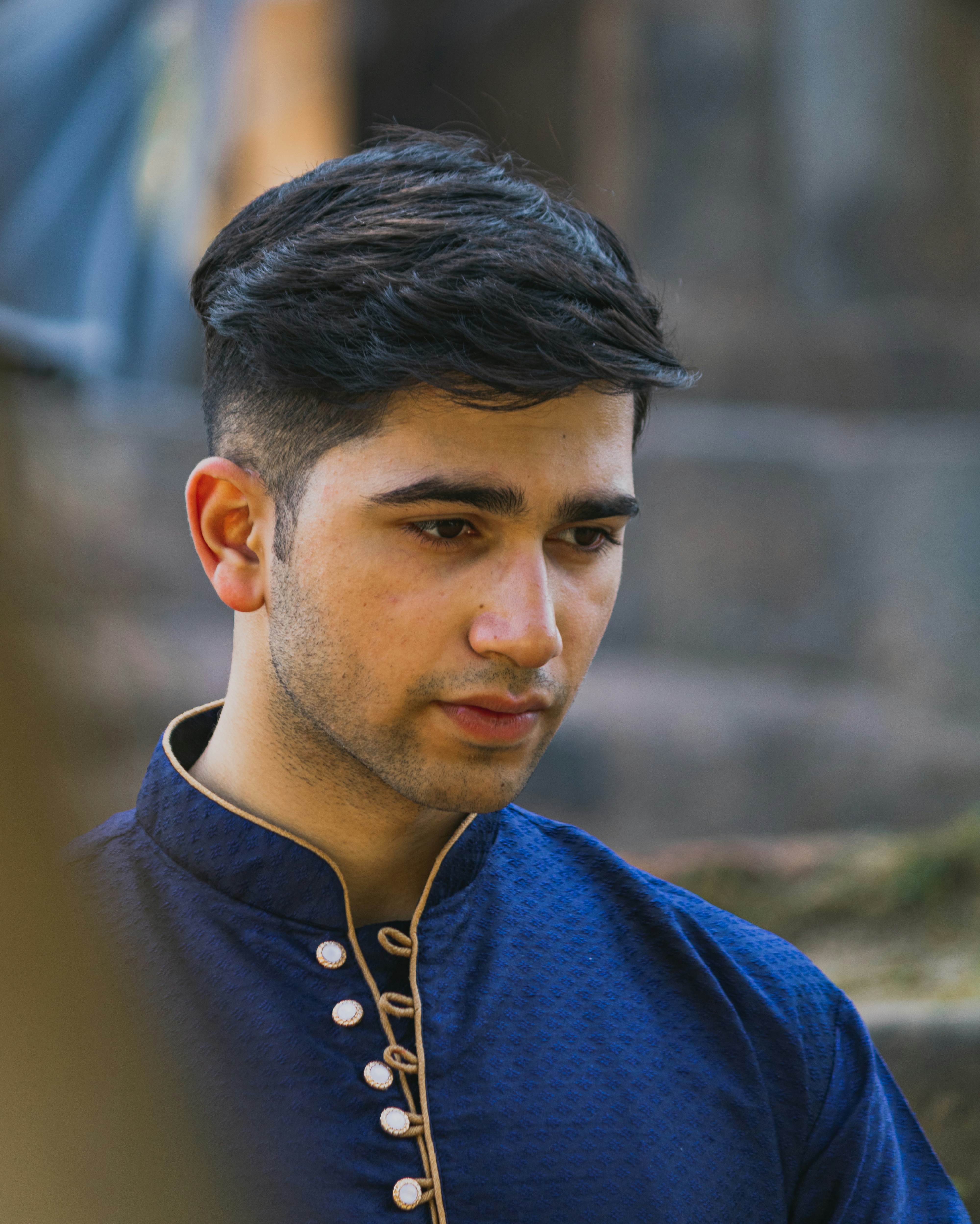 a man in a blue shirt looking at his cell phone
