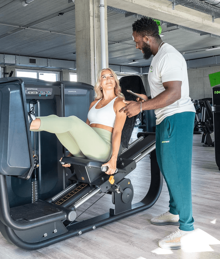 Zwei XTRAFIT-Trainer unterhalten sich im Cardio-Bereich eines XTRAFIT-Studios.