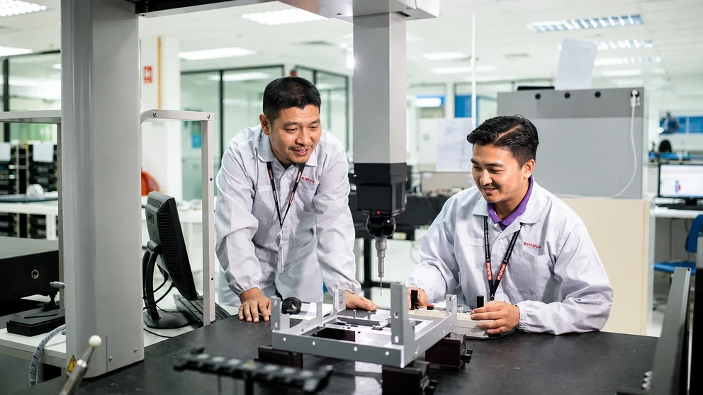 Engineers conducting precision measurement and quality inspection in a manufacturing laboratory.