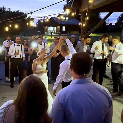 Wedding guests enjoying lively dance moves during a reception in Muskoka, with vibrant lights and upbeat music filling the air.