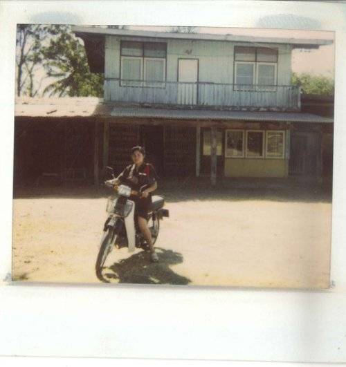 A mysteriously smiling woman covers her face with a newspaper