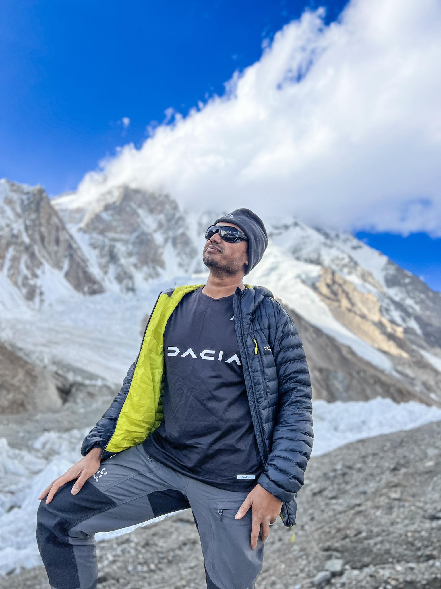 a man standing on top of a rock next to a tree